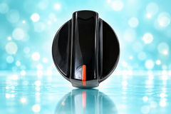 Frigidaire black range control knob on aqua background
