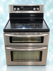Used stainless steel Frigidaire 30-inch double-oven electric stove on aqua background